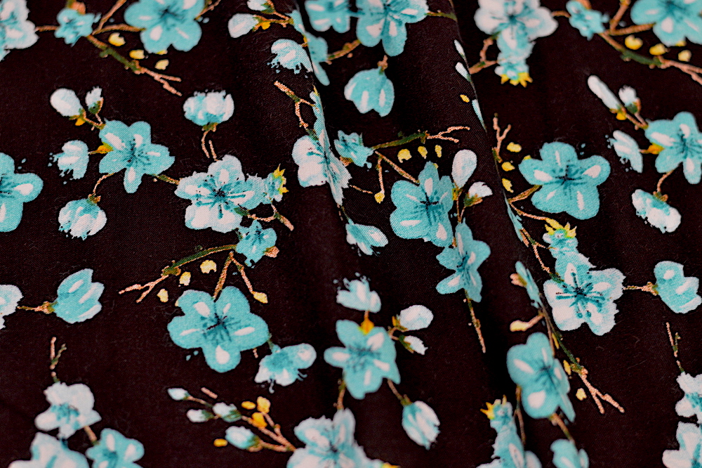 rayon challis with neon blue flowers on a black background